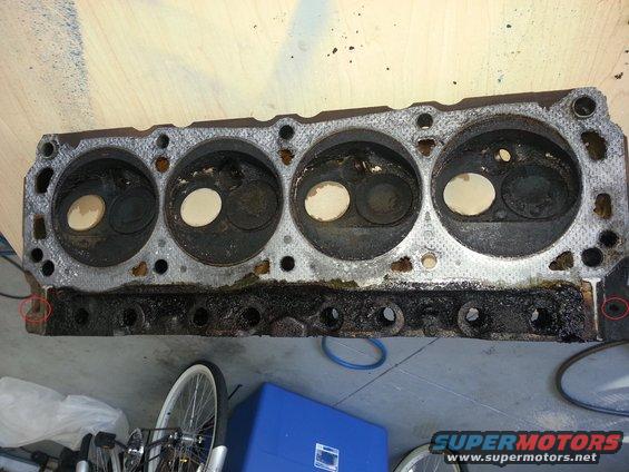 Engine cylinder head with four cylinders visible. It's dirty and appears to be removed from a vehicle