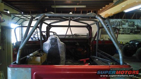 Red Jeep CJ interior with custom roll cage and covered seat