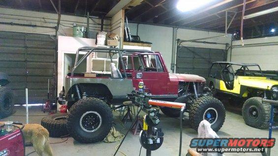 modified Jeep CJ with roll cage and large tires, another Jeep in background