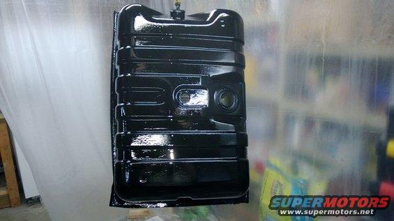 Black fuel tank with ribbed exterior, suspended for painting