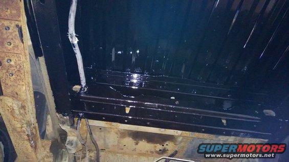 Underbody of a vehicle with black coating applied to frame rails and crossmembers