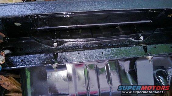 Underside of a vehicle showing frame and fuel tank