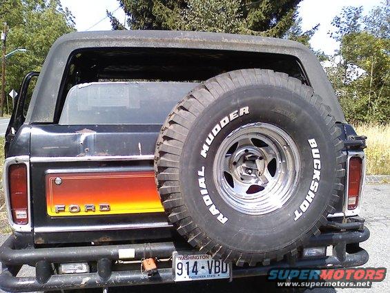 1978 Ford Bronco rear view showing spare tire mounted on tailgate, orange stripe on fender, and Washington license plate