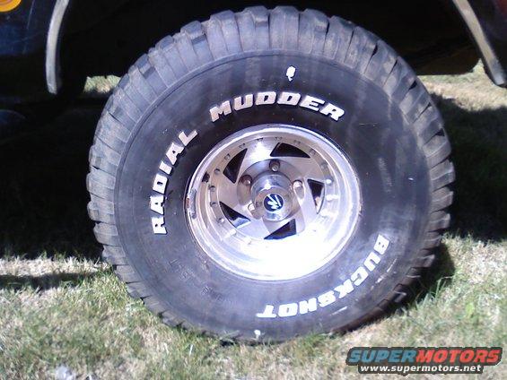 Off-road tire with 'Radial Mudder Buckshot' text and custom five-spoke wheel