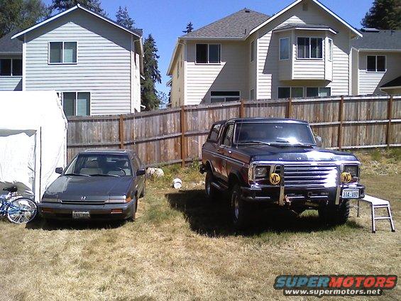 Ford Bronco parked next to a Honda Accord in a yard. Bronco has KC lights on the bumper
