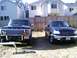 1979 Ford Bronco - Two Ford trucks parked in a yard, one is a 1979 F-Series and the other is a newer F-150.