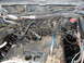 1979 Ford Bronco - Close-up view of engine bay components, including wiring harnesses and hoses.
