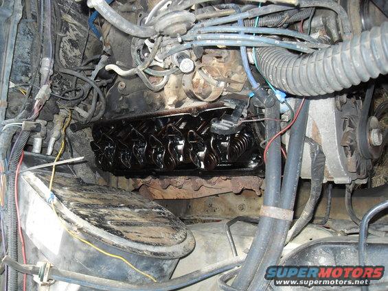 close-up of engine with valve cover off, showing rocker arms and oil
