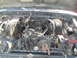 1979 Ford Bronco - The engine bay of a vehicle, showing a complex arrangement of wires, hoses, and engine parts.