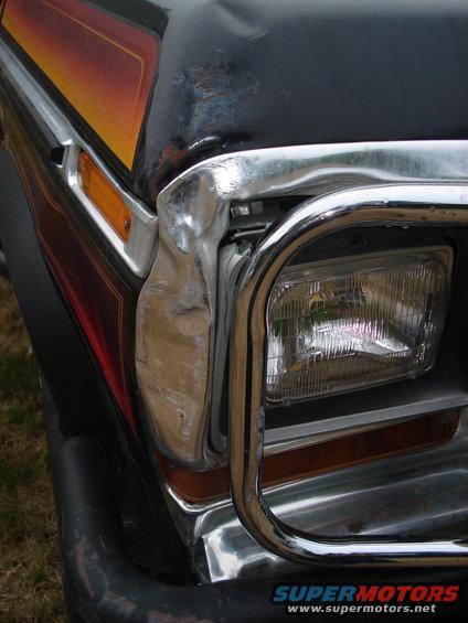 1979 Ford Bronco front fender with damage near headlight and chrome grille