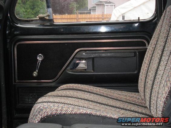 1979 Ford Bronco interior door panel with crank window and patterned seat fabric