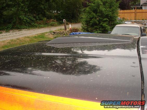 Black hood scoop on a dusty vehicle with orange accents