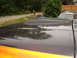 1979 Ford Bronco - A close-up of a black hood scoop on a vehicle with orange accents, with another vehicle visible in the background.