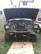 1979 Ford Bronco - The front of a truck is disassembled with the hood open, revealing the engine bay and radiator.
