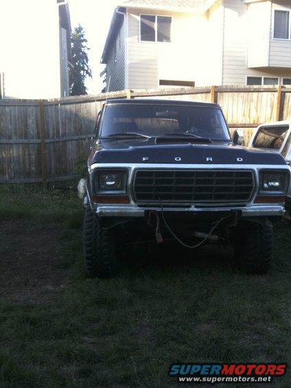 Front view of a black Ford Bronco with a grille that says FORD. It has large tires and appears to be lifted