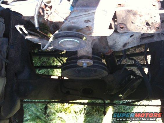 Engine bay view showing multiple pulleys and hoses. Some metal brackets are visible