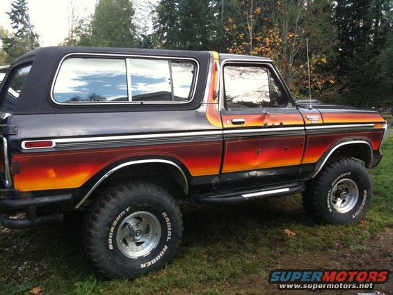 Side view of a 1979 Ford Bronco with sunset paint and lifted suspension