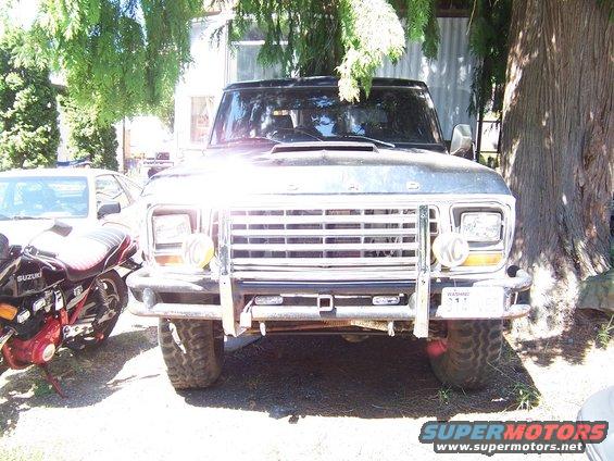 1979 Ford Bronco front view with bull bar and KC lights. Suzuki motorcycle parked to the left