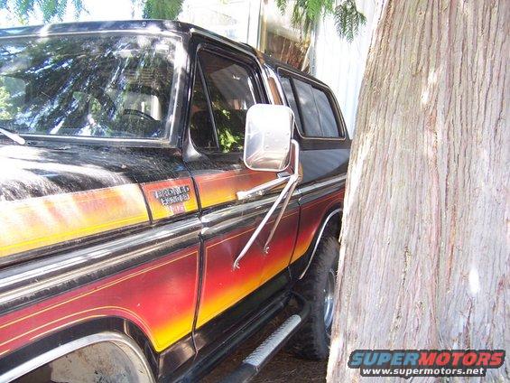 Black and red 1978 Ford Bronco with orange and yellow stripe detail, parked outdoors