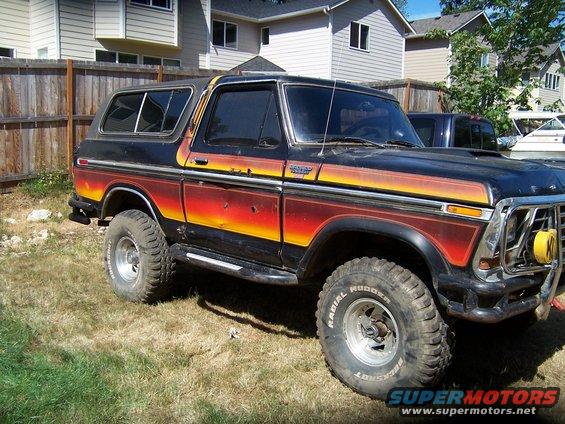 Ford Bronco with red, orange, and yellow stripe decals. Has aftermarket bumper and yellow fog light