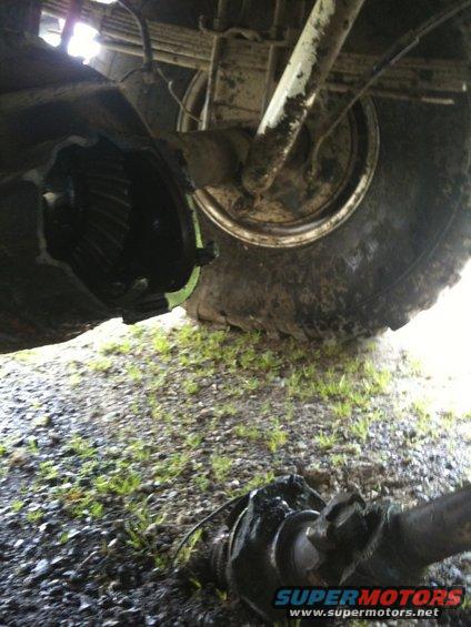 Underside view of a vehicle's rear differential and axle shaft, with the differential cover removed