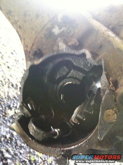 Damaged differential housing with broken gears visible inside
