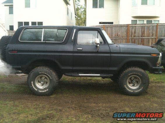 Black Ford Bronco, side view. Spare tire mounted on the rear