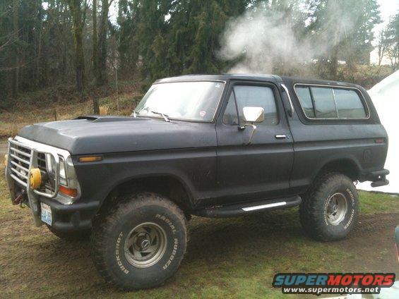 Black Ford Bronco with smoke coming from the roof, lifted with large tires