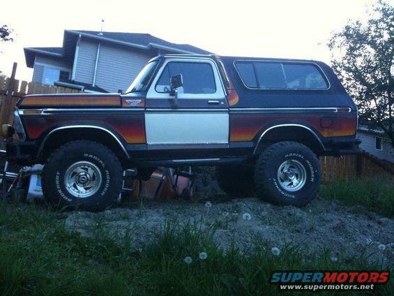 1979 Ford Bronco with two-tone paint and lifted suspension parked on dirt