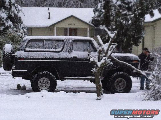 1979 Ford Bronco side view in snow with spare tire on back