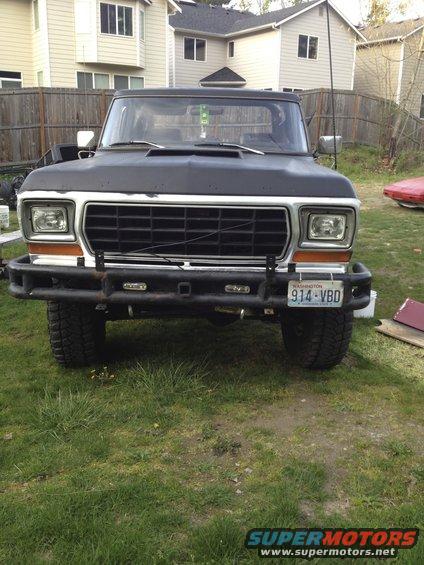 Black 1978 Ford Bronco with aftermarket bumper and off-road tires, front view
