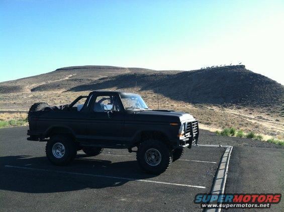 Black Ford Bronco parked in a lot with a spare tire on the back