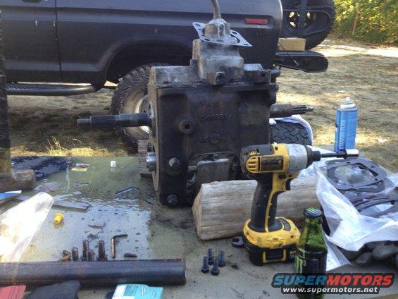 Transmission and tools laid out on a table next to a dark-colored truck