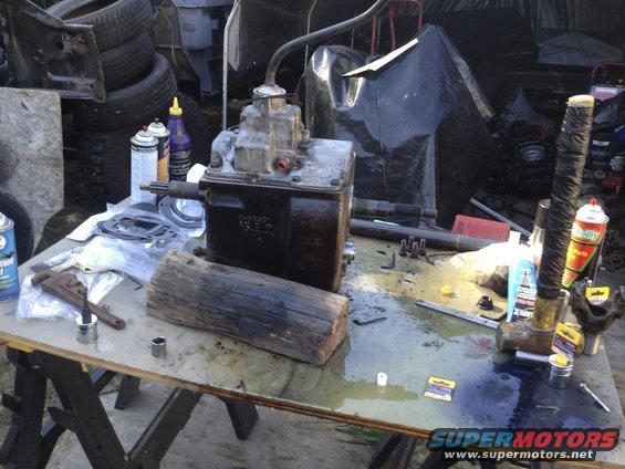 Transmission part on a workbench with tools and spray cans