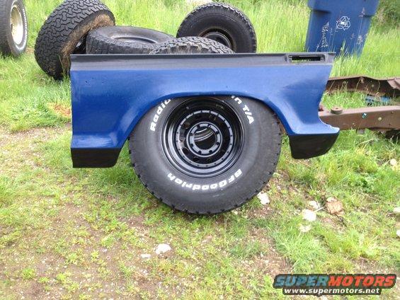 Blue truck bed section with BFGoodrich Radial T/A tires and spare tires stacked behind it