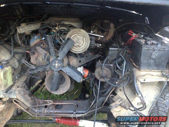1979 Ford Bronco engine bay with fan and battery visible
