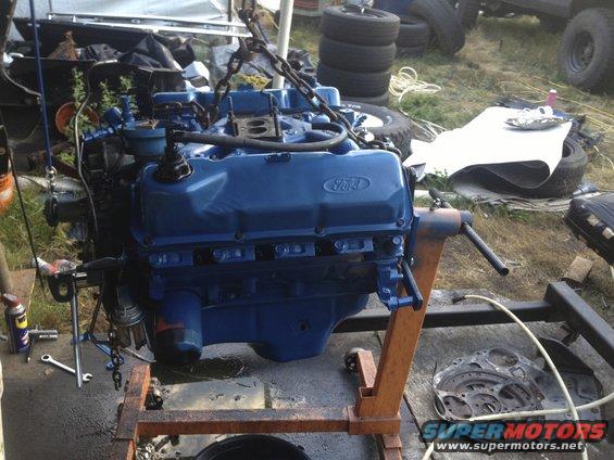 Blue Ford V8 engine on an orange engine stand, with chains attached