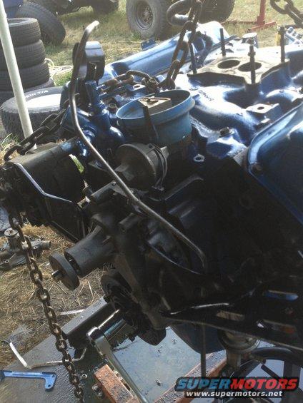 Engine block assembly suspended by chains, with various components attached