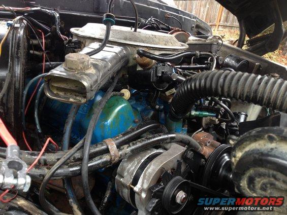 Engine bay with blue painted block, alternator, and air intake assembly