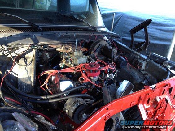 Engine bay with red spark plug wires and carburetor