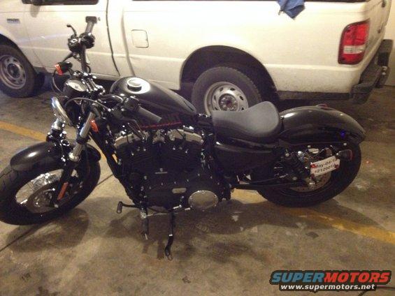 Black motorcycle parked in front of a white pickup truck
