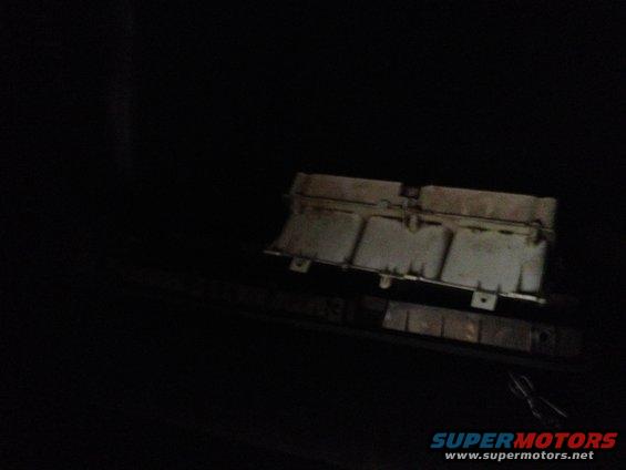 Engine part, possibly an air cleaner housing, in dark lighting