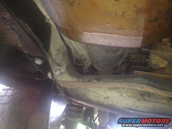 Underside view of vehicle frame, suspension components, and part of a tire