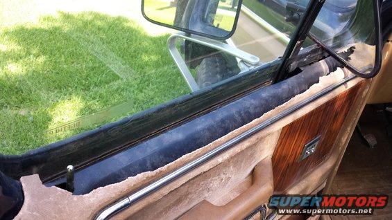 1984 Ford Bronco interior door panel with wood grain trim and chrome handle