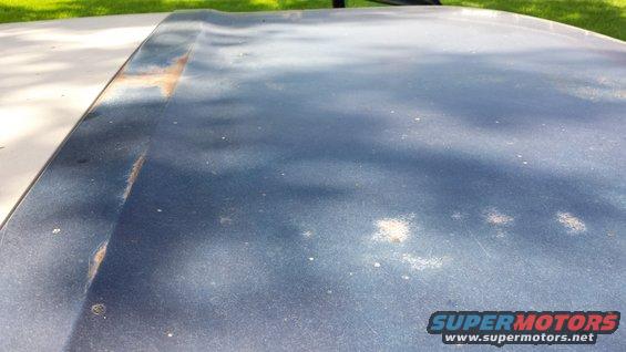 Dark blue hood with rust along the seam and white specks