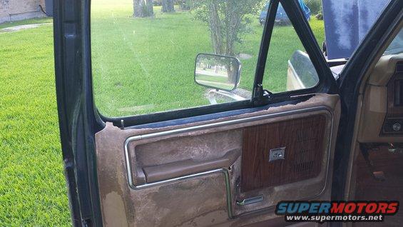 Interior door panel with wood grain trim and chrome accents