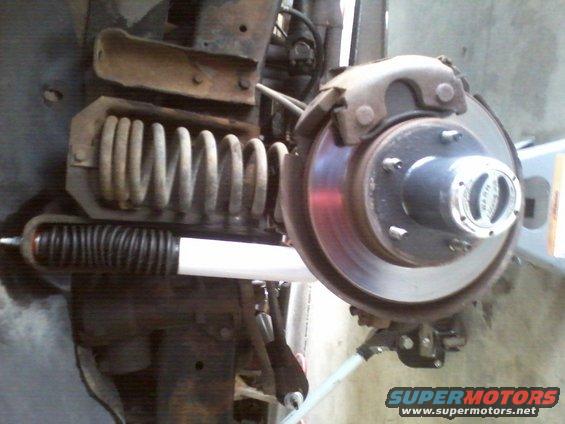 Front suspension coil spring and shock absorber with brake rotor and hub