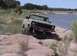 1978 Ford Bronco - 1978 Ford Bronco navigating rocky terrain next to a lake.