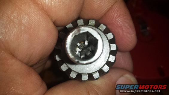 Close-up of a hand holding a splined socket tool with a hexagonal opening