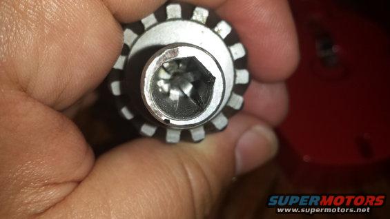 Close-up of a socket wrench head with a hex opening, held by a hand